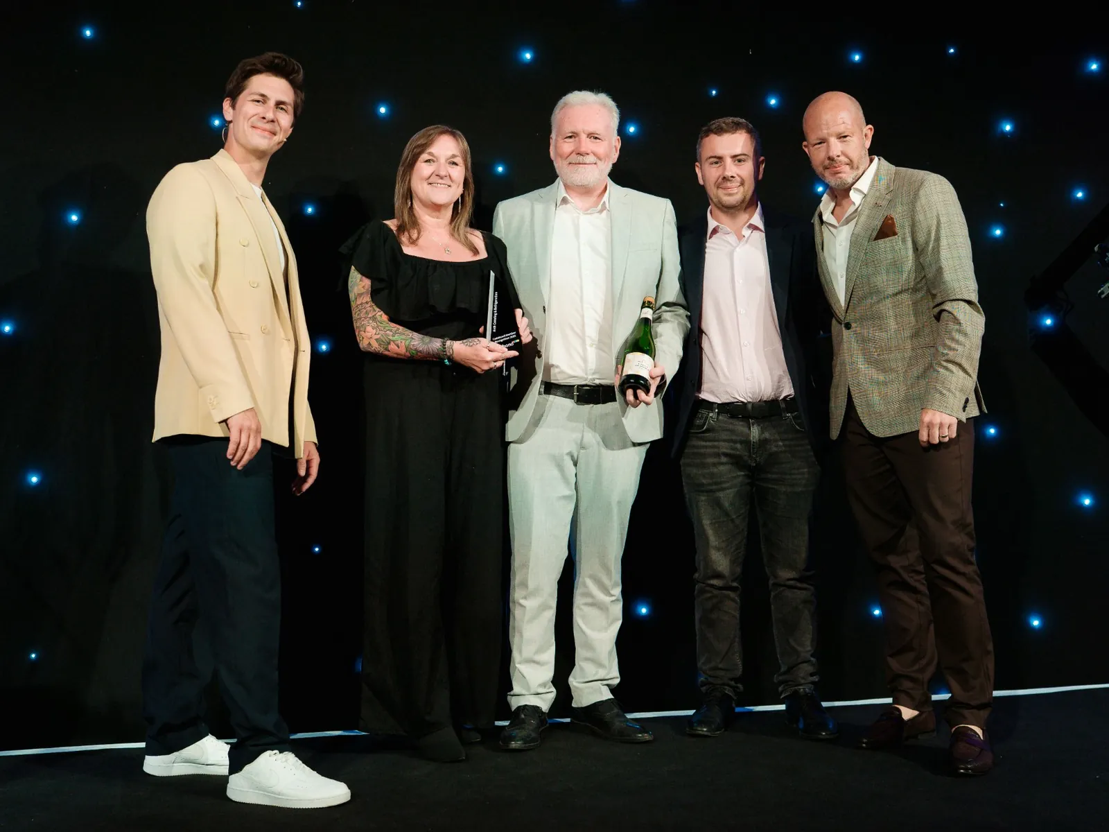 Simon and Rebecca Rutt on stage at the Cedabond Showcase Awards, accepting the Cedabond Members Recognition Award