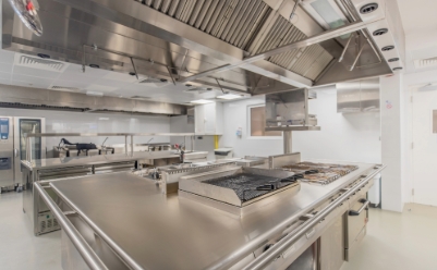 Professional installation team setting up commercial kitchen equipment with precision and care